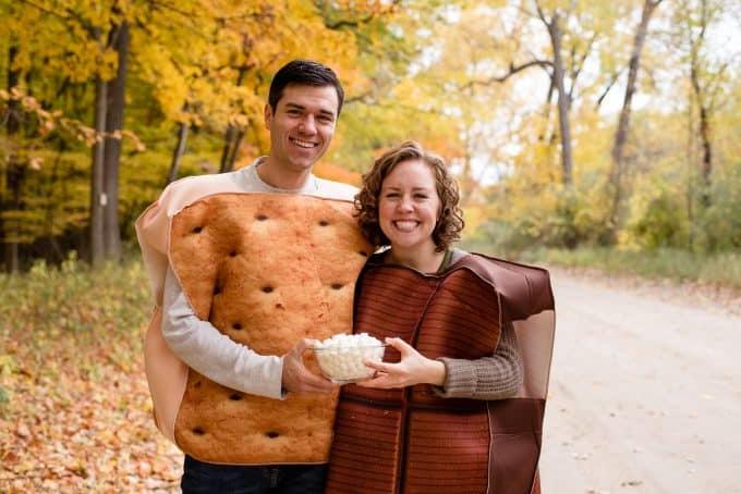 Coppia felice con vestiti a tema s'more per l'annuncio di gravidanza