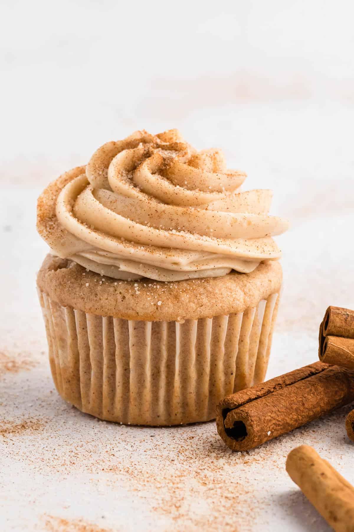 Glaseado de queso crema con canela en un cupcake con canela en rama y azúcar de canela