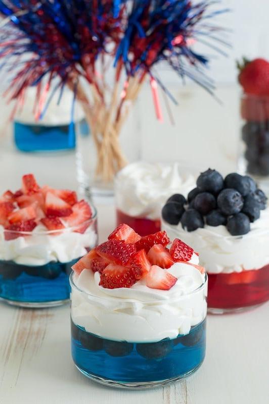 Bicchierino di gelatina blu con panna montata e fragole tritate