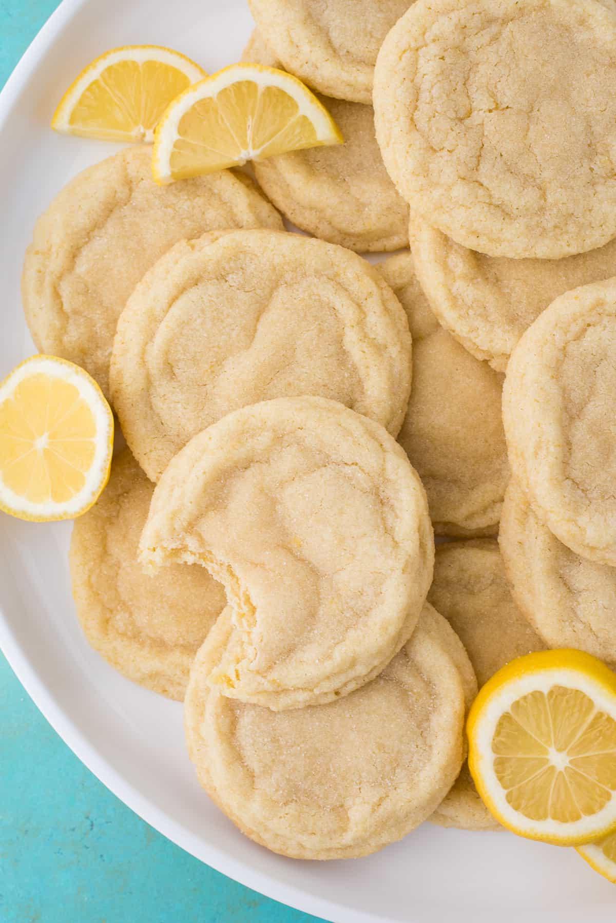 Biscotti al limone con fette di limone su piatto bianco su sfondo blu