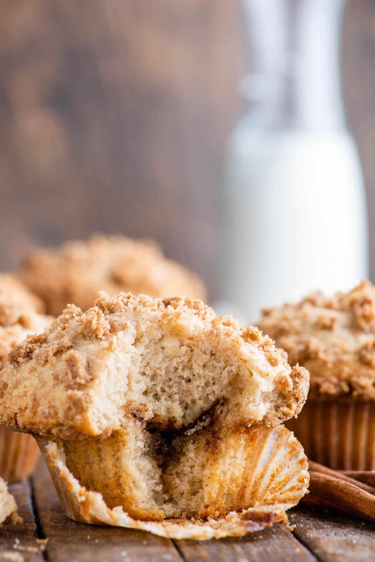 muffin al caffè con un morso che mostra lo strato di cannella all'interno su sfondo di legno