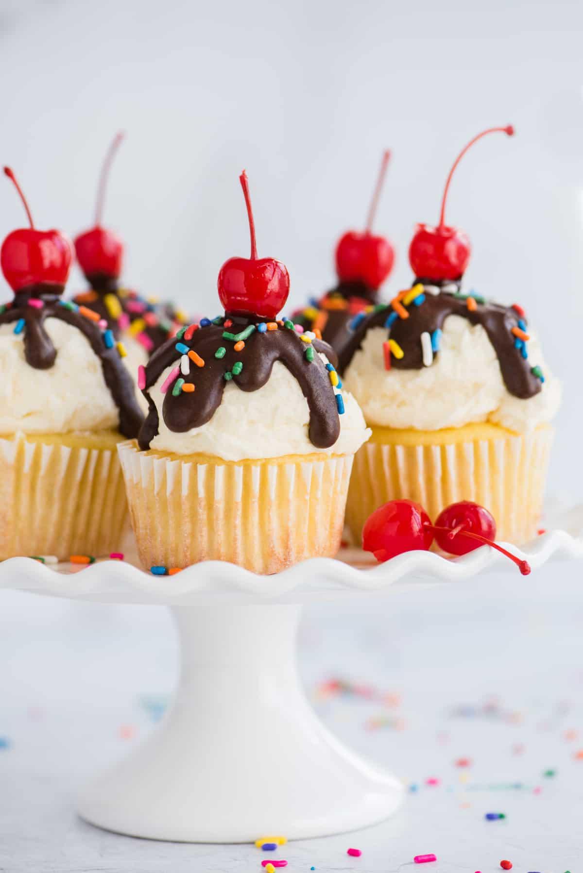ice cream cupcakes displayed on white cake stand on white background
