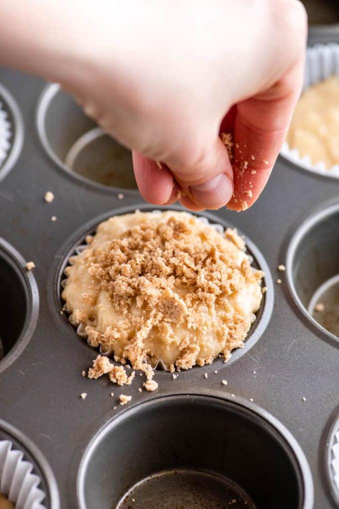 mano che aggiunge la copertura crumble al muffin
