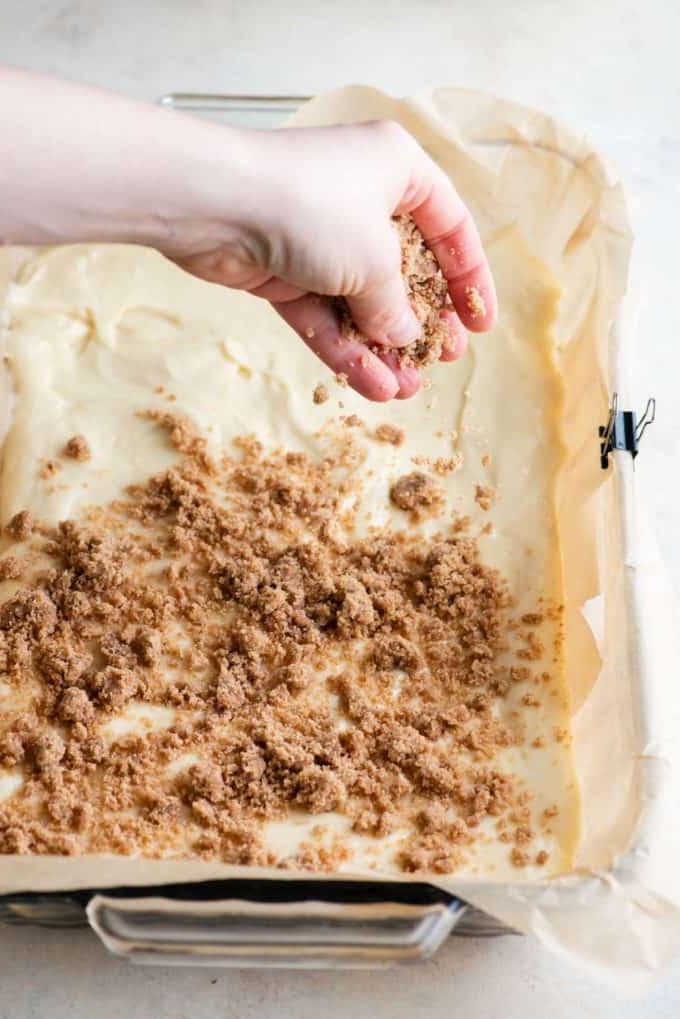 Topping di crumble sparso in una teglia foderata con carta forno