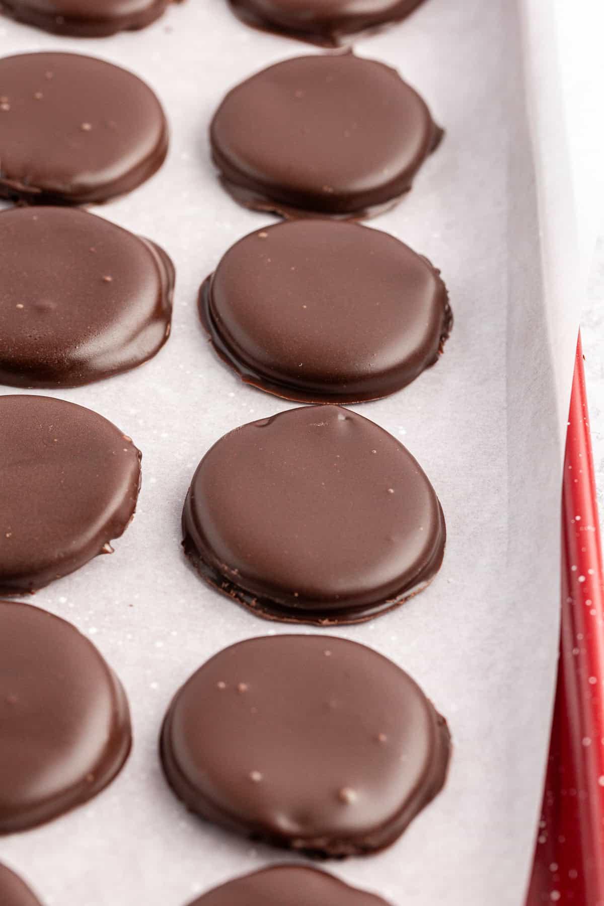 File di patties alla menta su una teglia foderata con carta forno