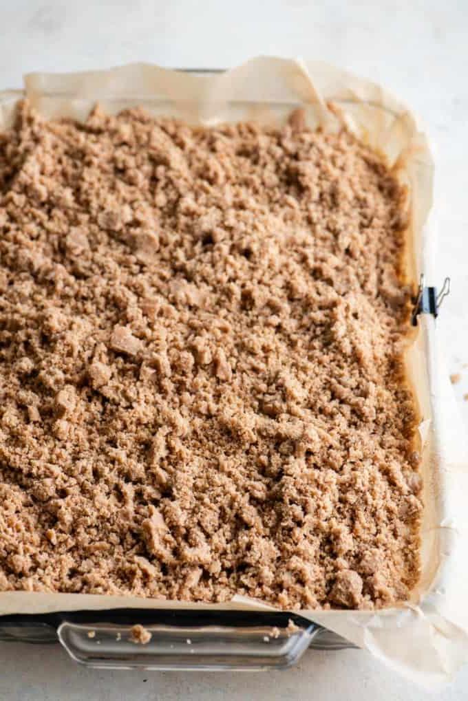 Impasto di torta al caffè con topping di crumble in una teglia foderata con carta forno