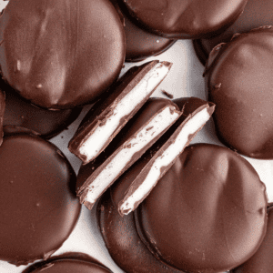Patties alla menta sparsi e impilati con tre metà al centro sui lati, che mostrano il ripieno bianco di menta