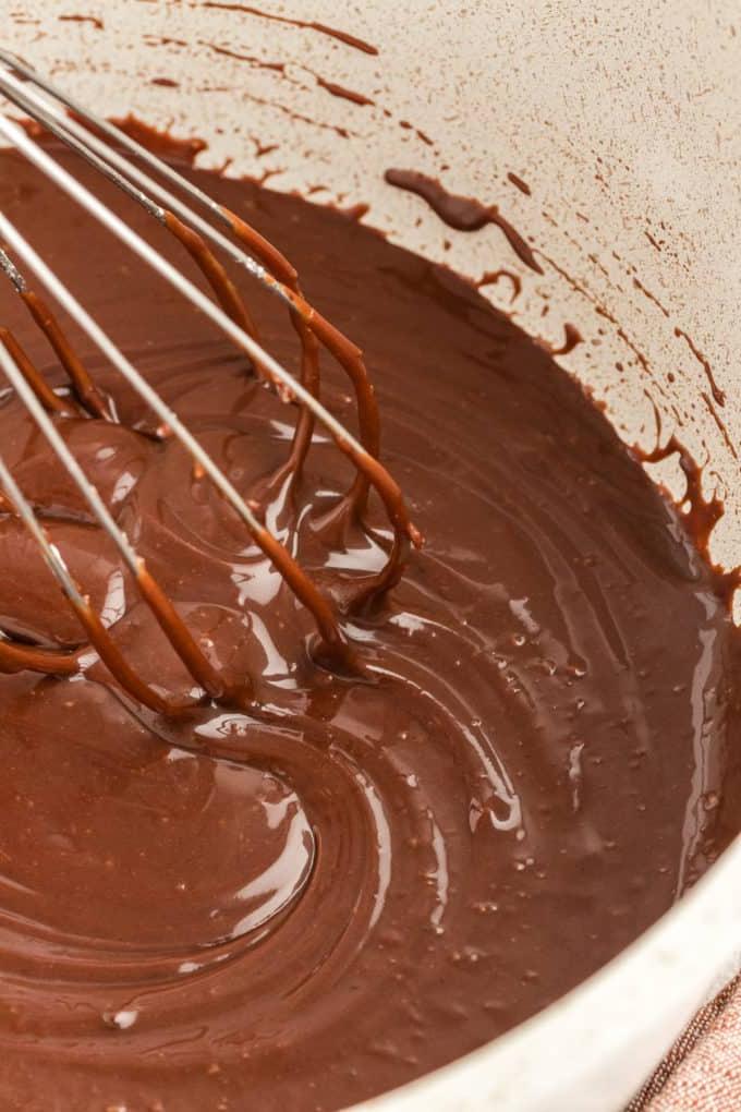 Primo piano della glassa al cioccolato mescolata in una casseruola