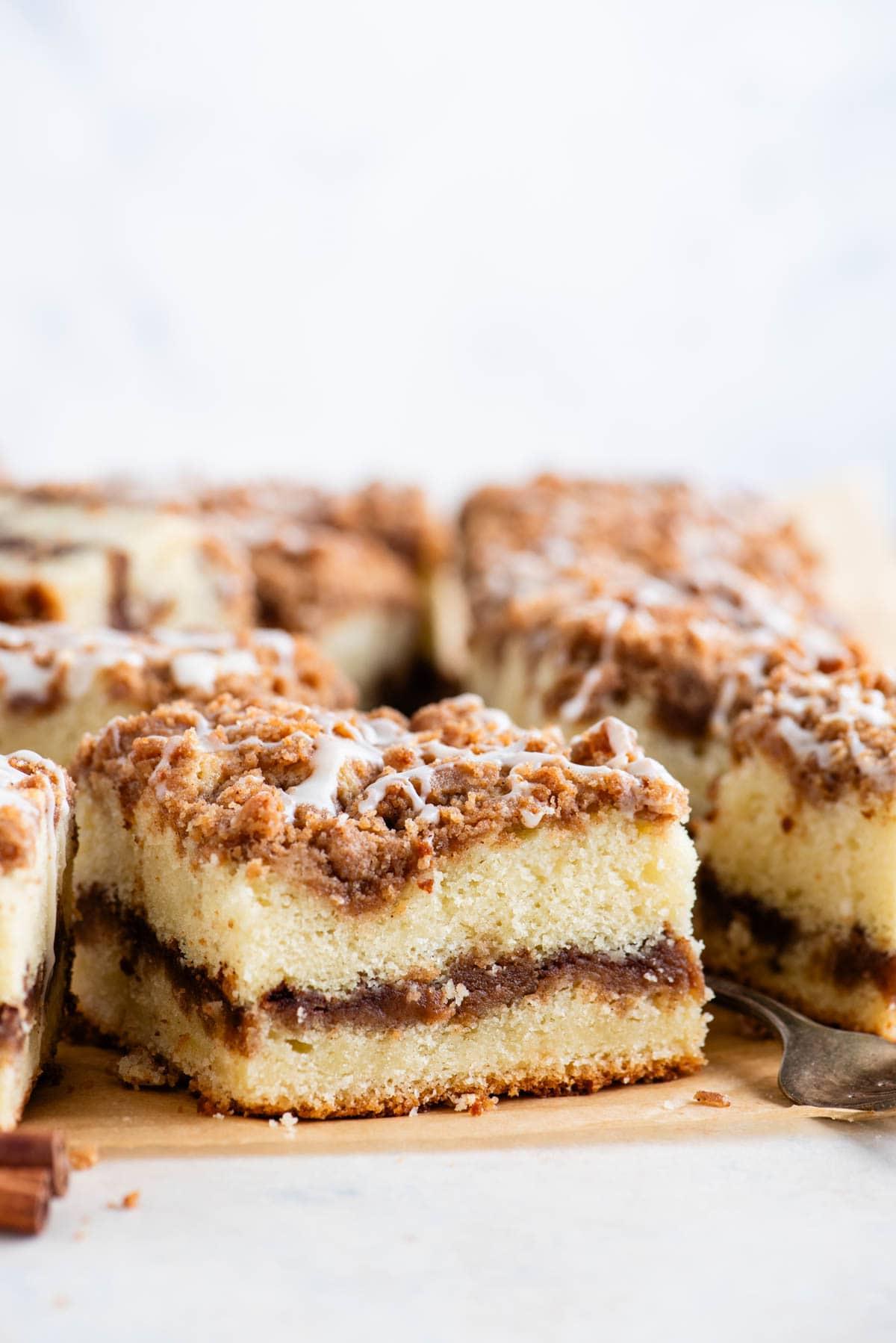 Fette quadrate di torta al caffè con una forchetta e un bastoncino di cannella