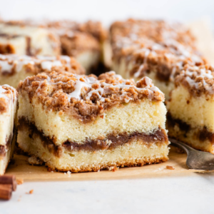 Fette quadrate di torta al caffè con una forchetta e un bastoncino di cannella