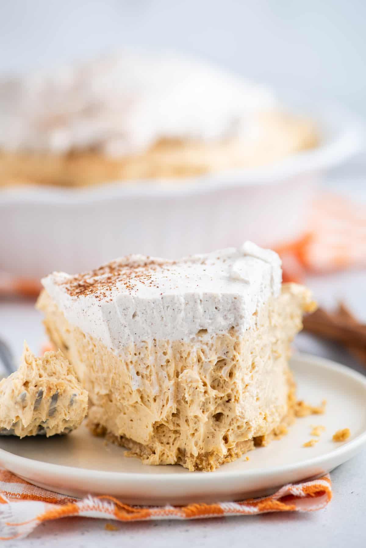 Una forchetta taglia una fetta di torta di zucca senza cottura.