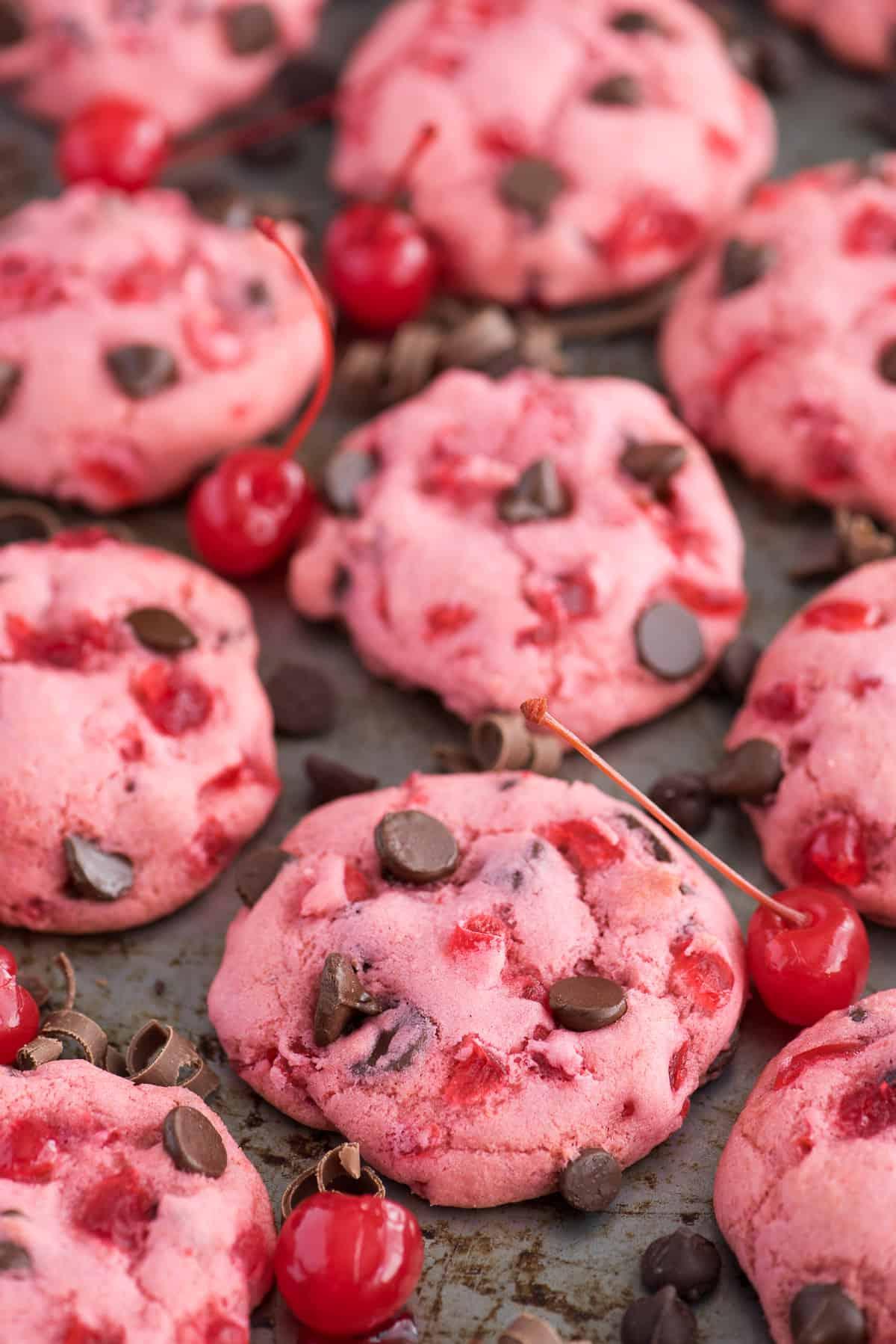 biscotti rosa alle ciliegie maraschino e gocce di cioccolato su teglia con ciliegie e gocce di cioccolato
