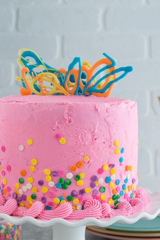 Questa torta rosa confetti con gocce di cioccolato è così divertente e colorata. Ci sono mini gocce di cioccolato all'interno della torta!