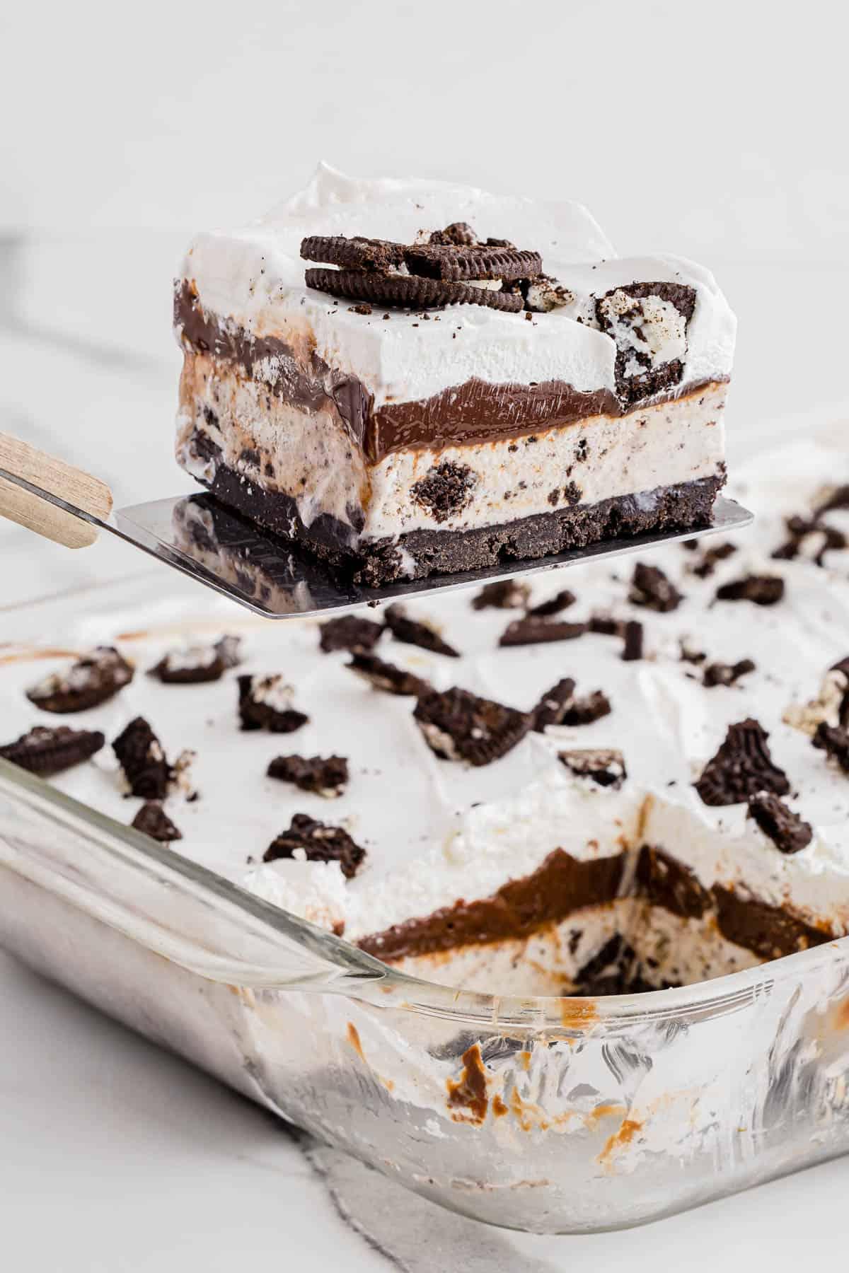 Ricetta Torta Gelato Oreo con 5 Ingredienti 3 Una fetta di torta gelato Oreo che viene sollevata da un piatto con una spatola