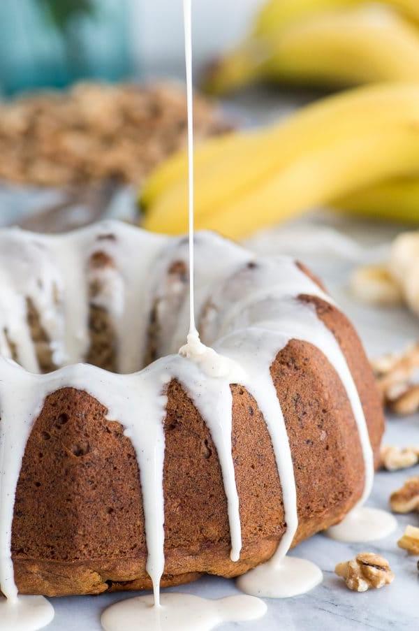 Fetta di torta Bundt di banana e noci con glassa alla vaniglia, pronta per essere gustata.