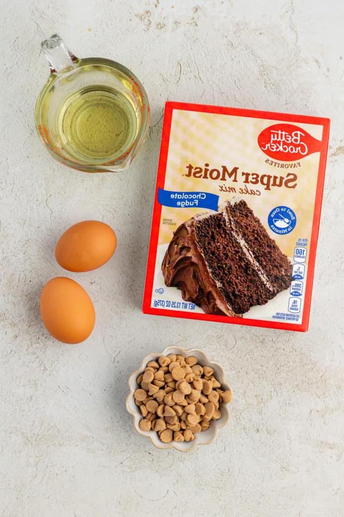 Ingredienti per biscotti cioccolato e burro d'arachidi con preparato per torte, inclusi una scatola di preparato per torte al cioccolato, due uova, gocce di burro d'arachidi e olio vegetale