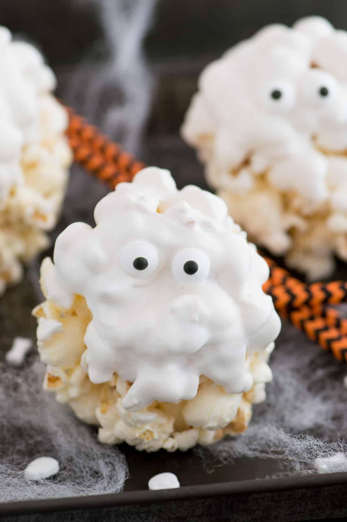 Palle di popcorn ricoperte di cioccolato bianco con occhietti di zucchero per assomigliare a fantasmi