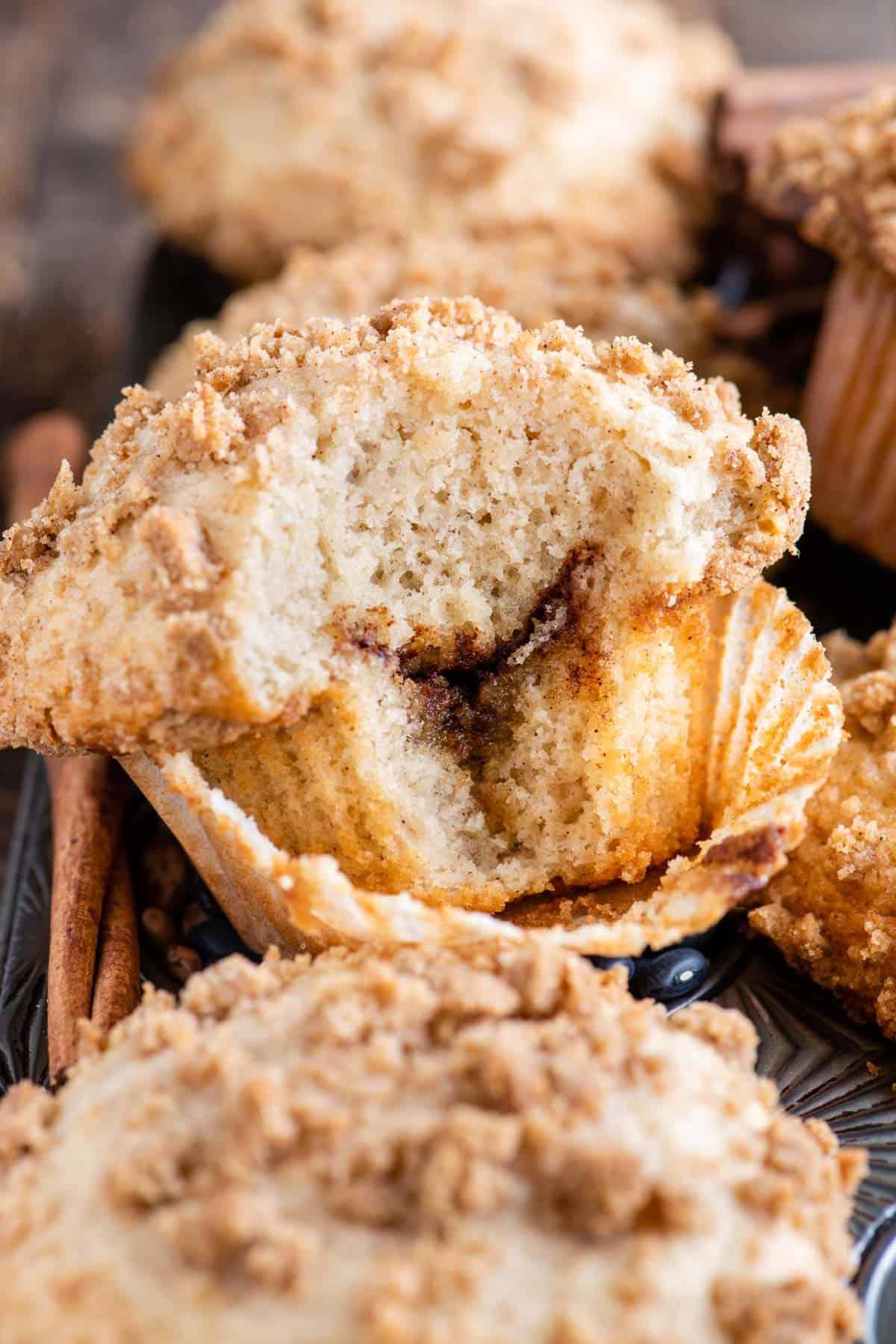 muffin al caffè con un morso che mostra lo strato di cannella all'interno nella teglia da muffin metallica