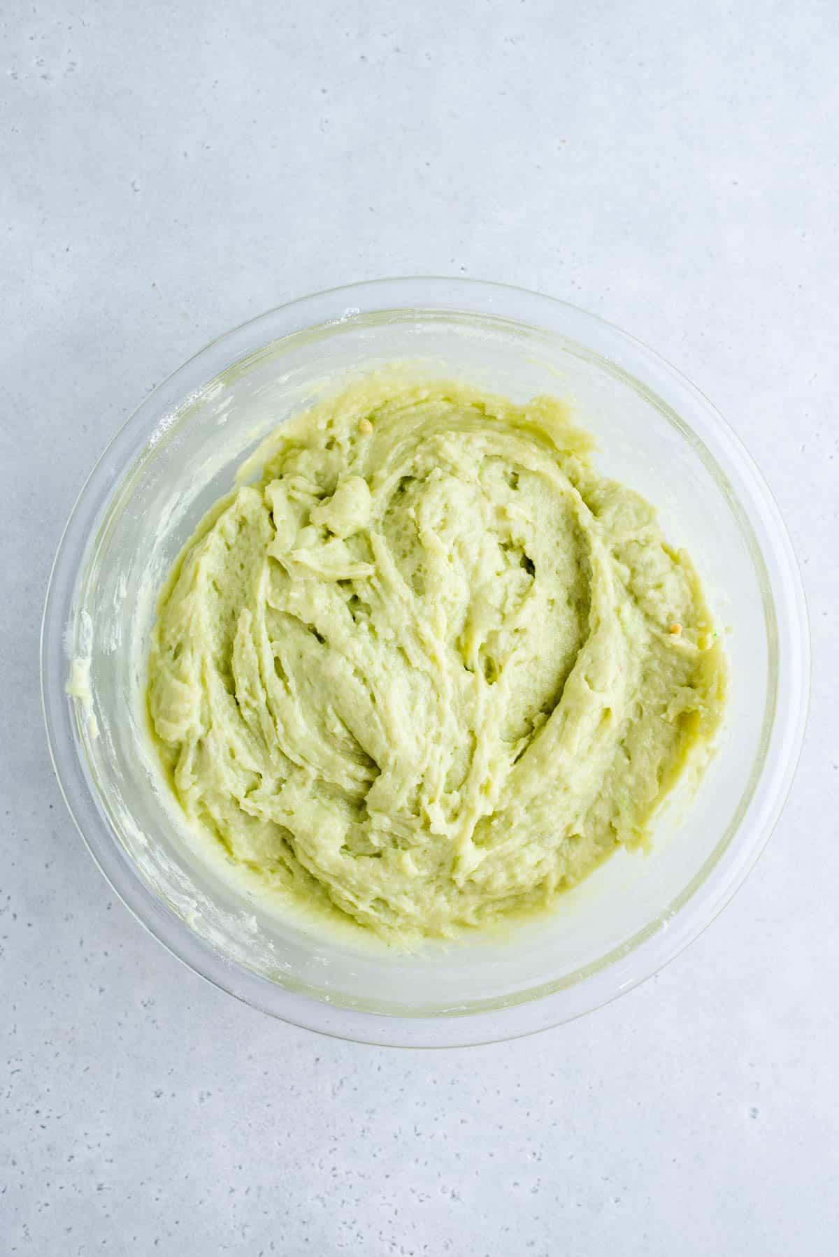 Muffin al Pistacchio 4 Pistachio muffin batter in a clear glass mixing bowl.