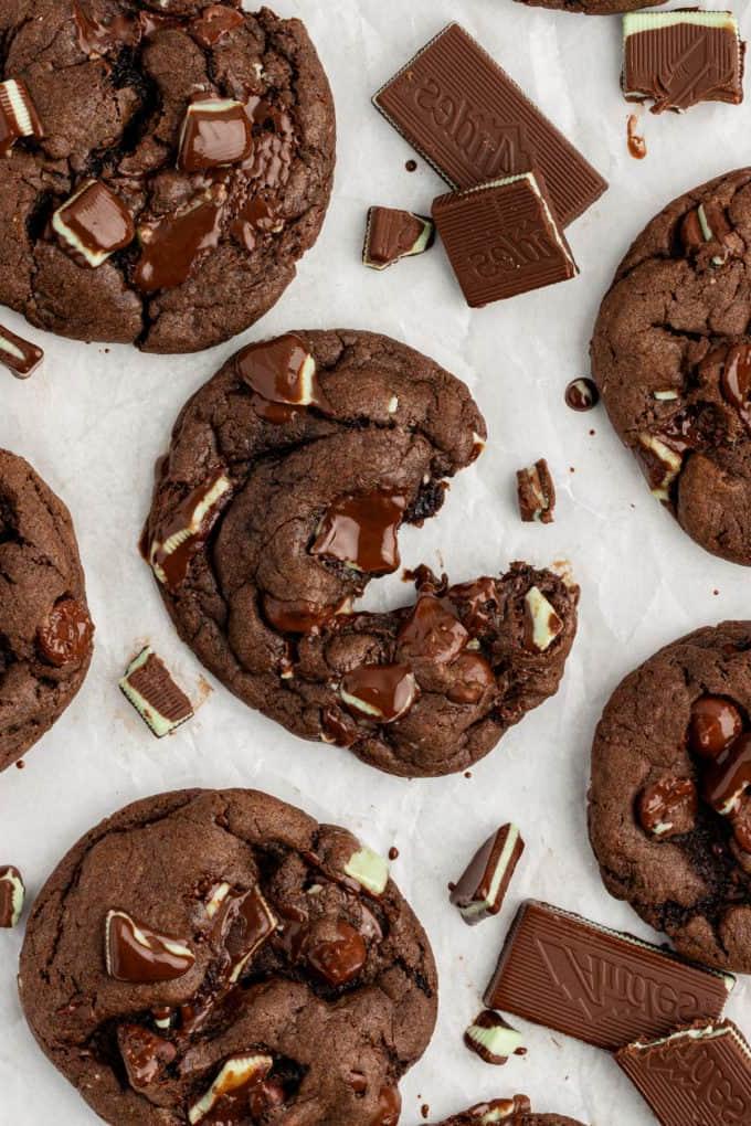 Biscotti Andes Mint su carta bianca con cioccolato fuso appiccicoso al loro interno, il biscotto centrale parzialmente aperto e pezzetti di Andes mints sparsi