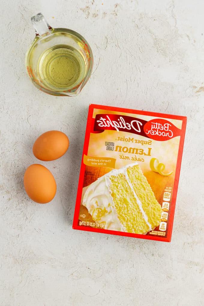 Ingredienti per biscotti al limone con preparato per torte, inclusi una scatola di preparato per torte al limone, due uova, e olio vegetale