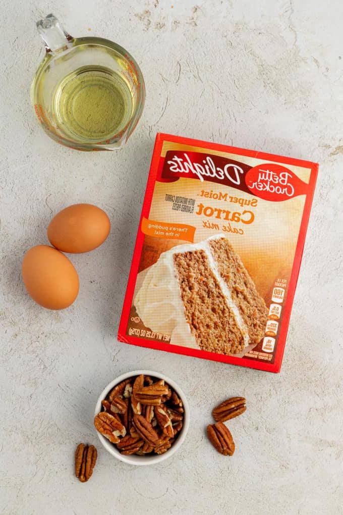 Ingredienti per biscotti torta di carote con preparato per torte, inclusi preparato per torta di carote, due uova, noci pecan e olio vegetale