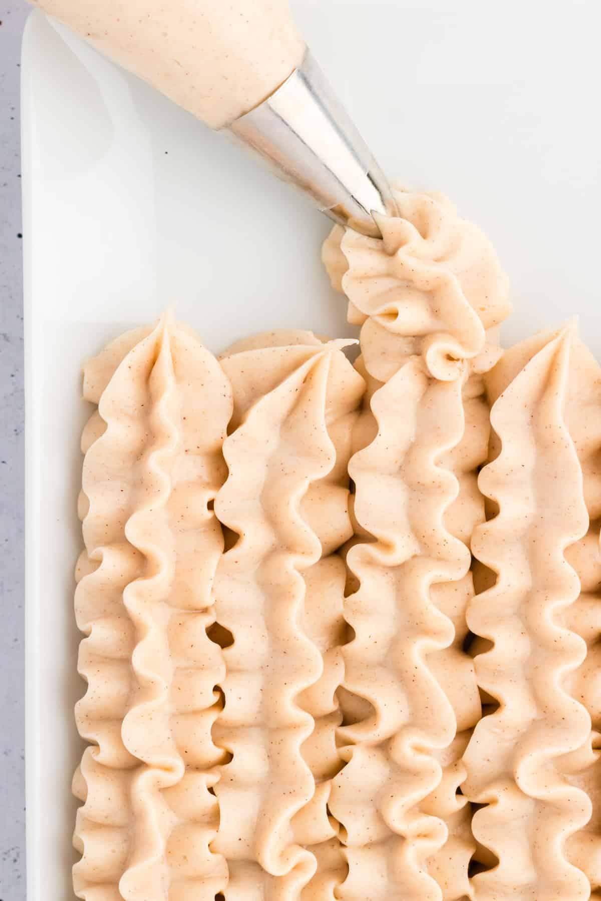 Glaseado de queso crema con canela en líneas en un plato blanco