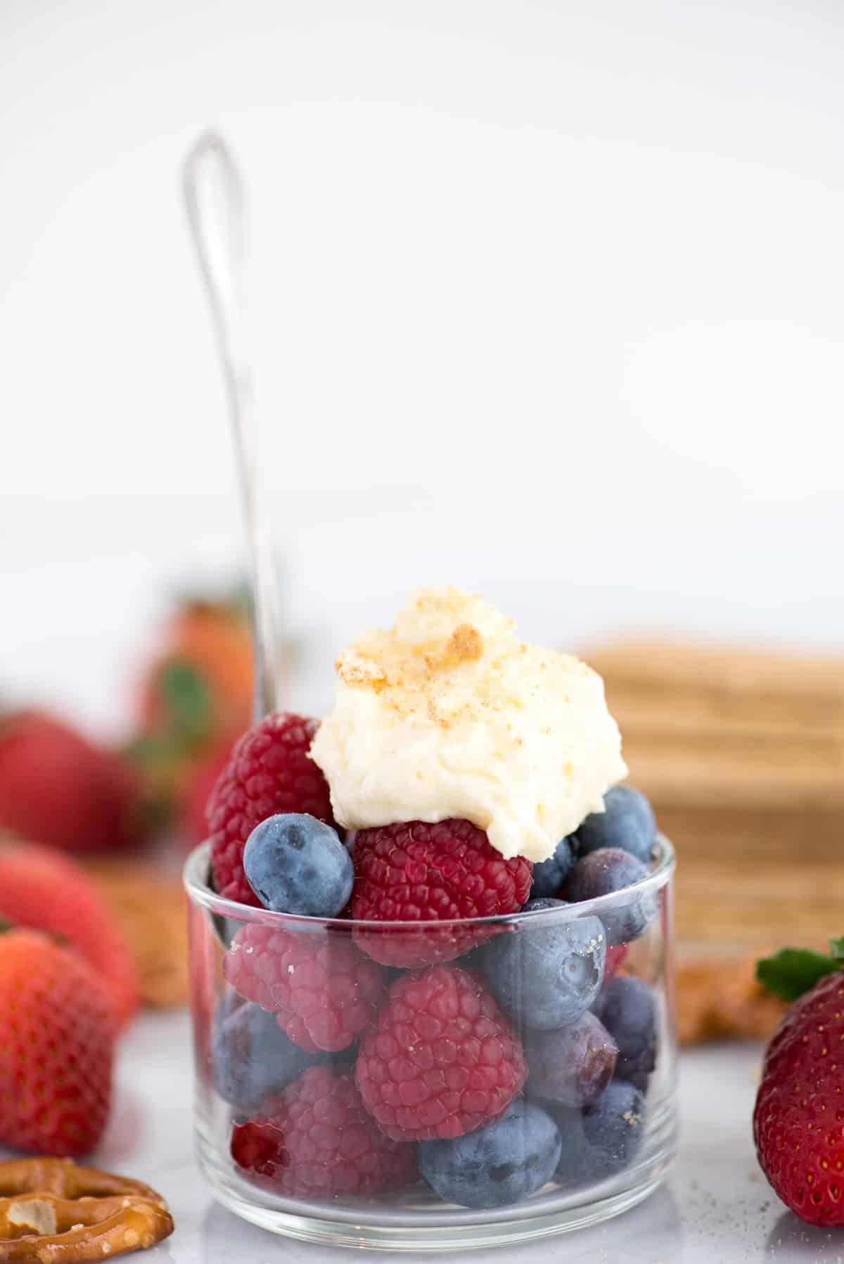 Panna montata al cheesecake su una ciotola di lamponi e mirtilli
