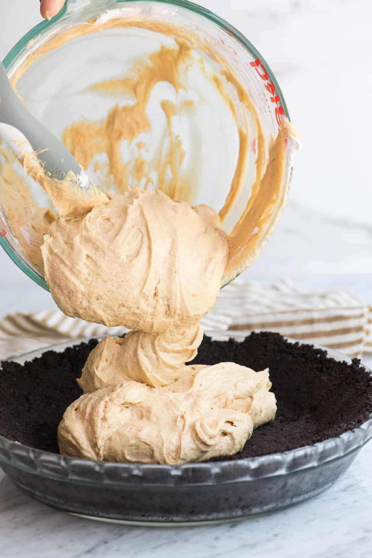 Il ripieno al burro di arachidi viene versato nella crosta di Oreo per la torta.
