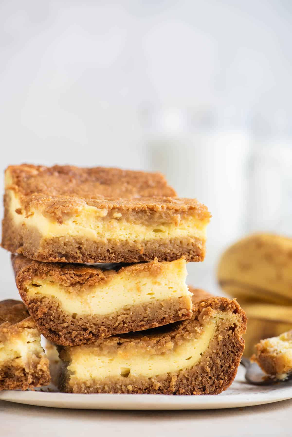 Tre brownies al budino di banana impilati su un piatto con banane sullo sfondo