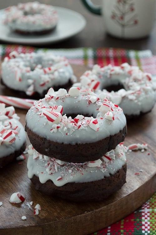 Ciambelle al Cioccolato e Bastoncino di Zucchero 5 Ciambelle al cioccolato cotte al forno, aromatizzate alla menta piperita, guarnite con cioccolato bianco e bastoncini di zucchero tritati.