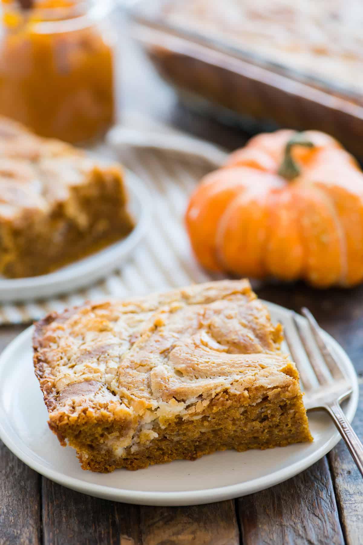 Torta Terremoto alla Zucca 5 Fetta di torta terremoto alla zucca su piatto bianco con zucca sullo sfondo
