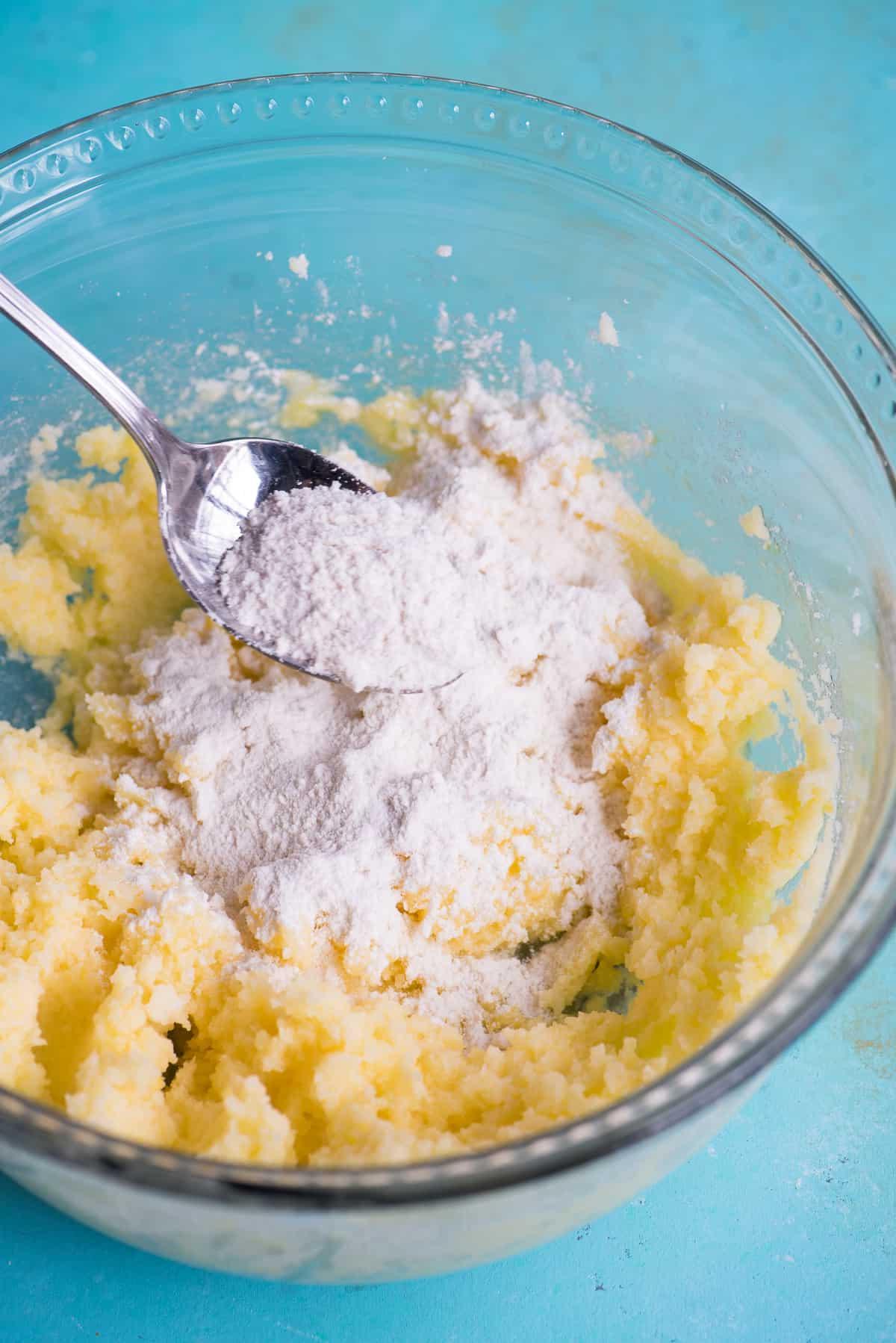 Impasto per biscotti con ingredienti secchi in una ciotola di vetro su sfondo blu