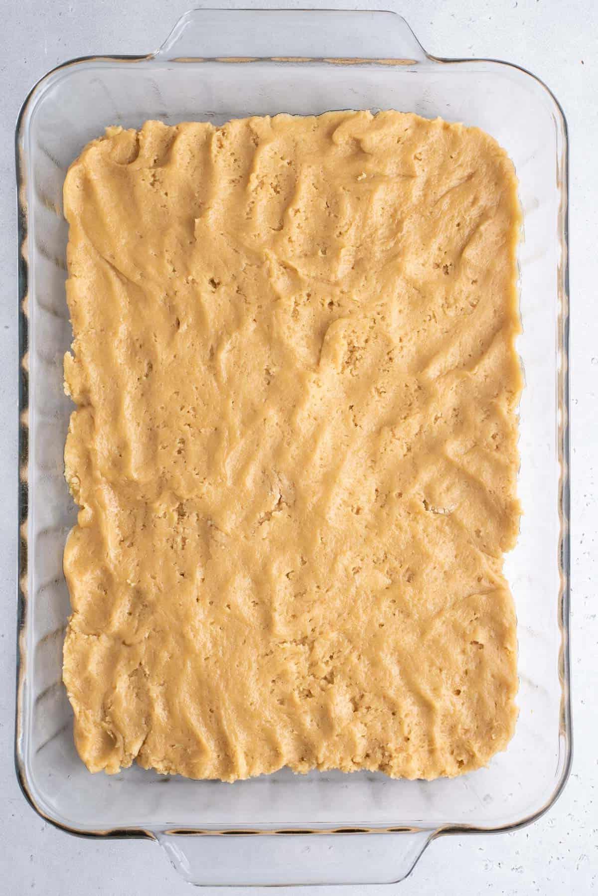 Impasto blondie pressato in uno strato piatto in una teglia trasparente