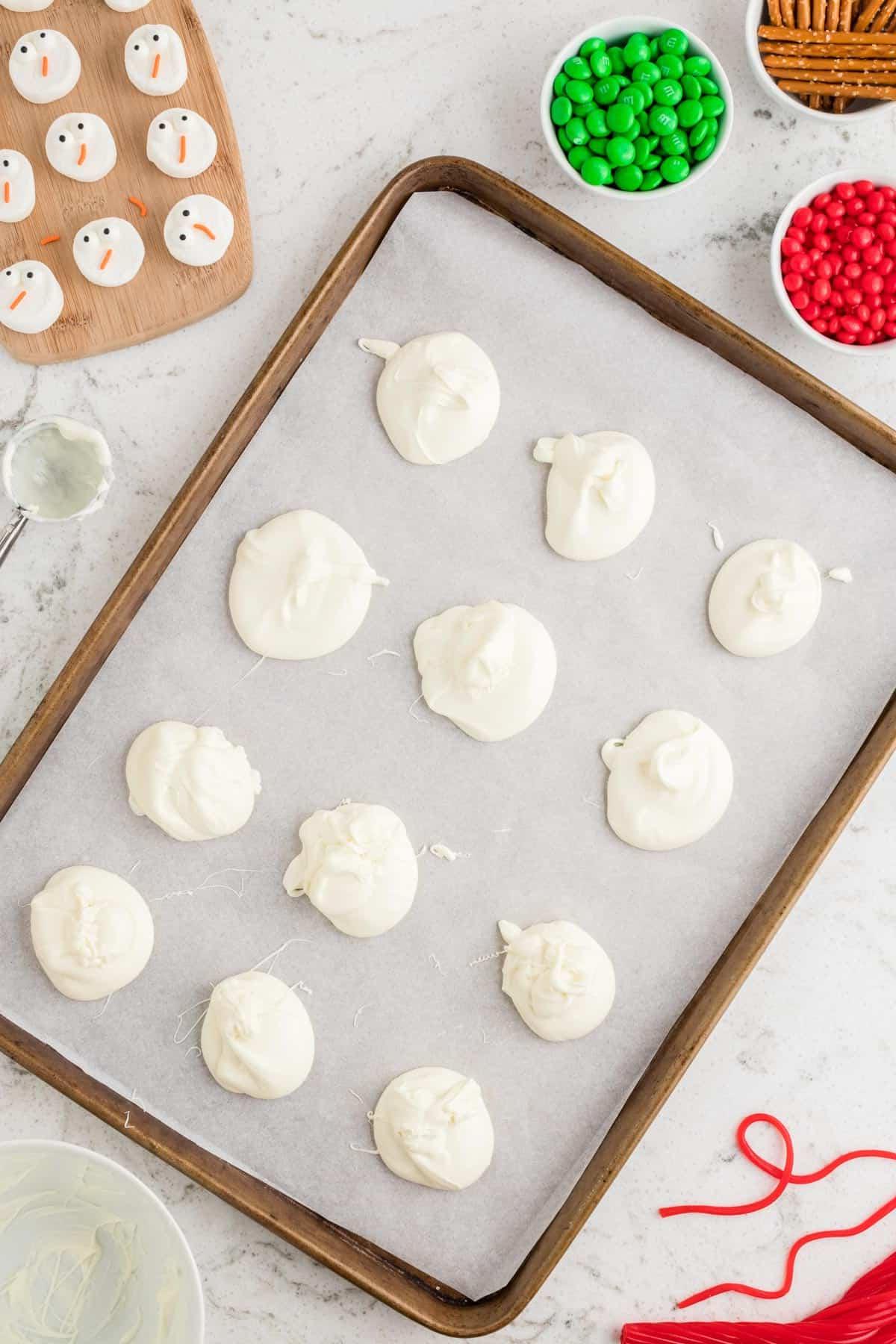 Corteccia del Pupazzo di Neve Sciolto 6 cioccolato bianco fuso disposto a gocce su carta forno