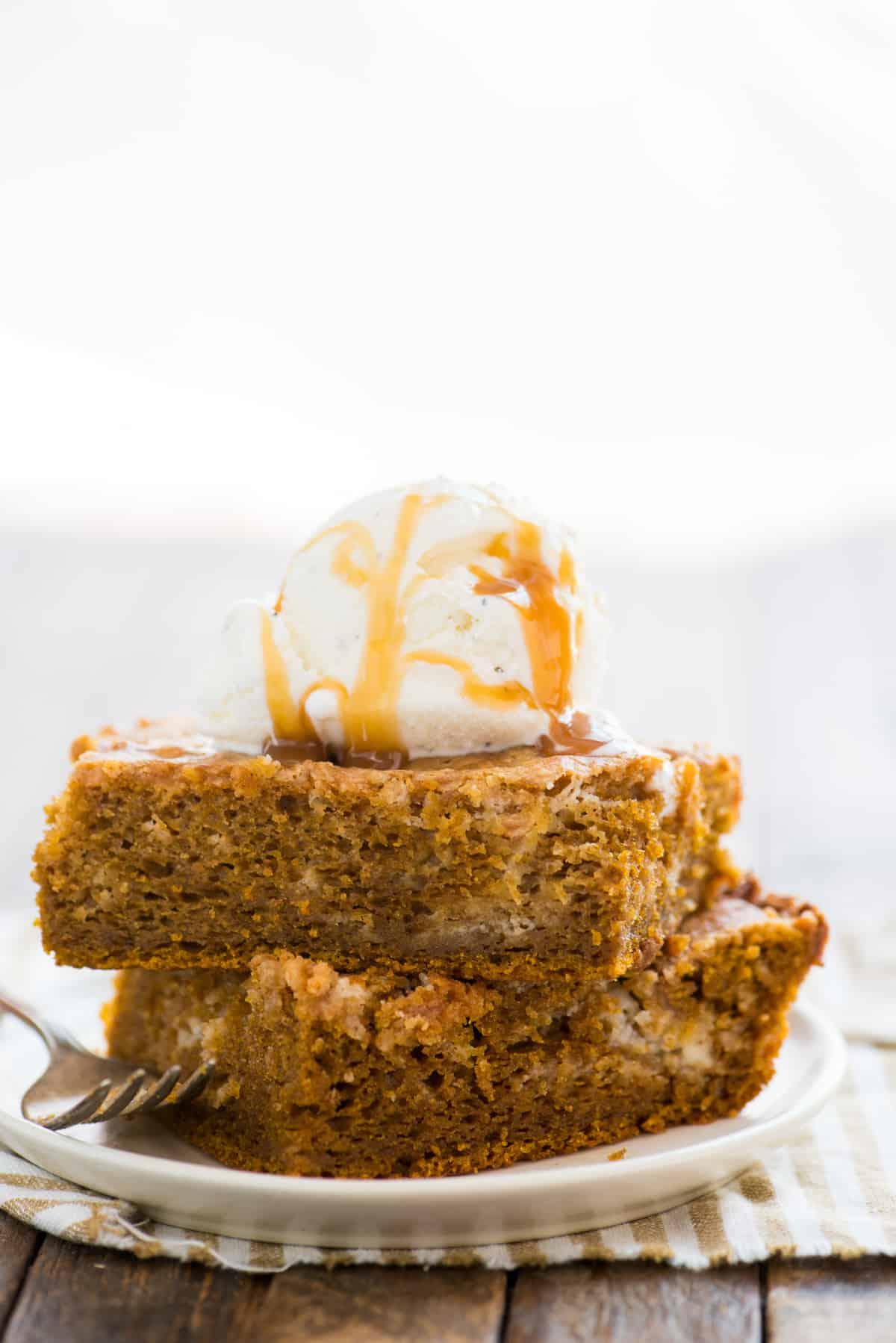 Torta Terremoto alla Zucca 6 Due fette di torta terremoto alla zucca impilate l'una sull'altra su piatto bianco con una pallina di gelato alla vaniglia sopra