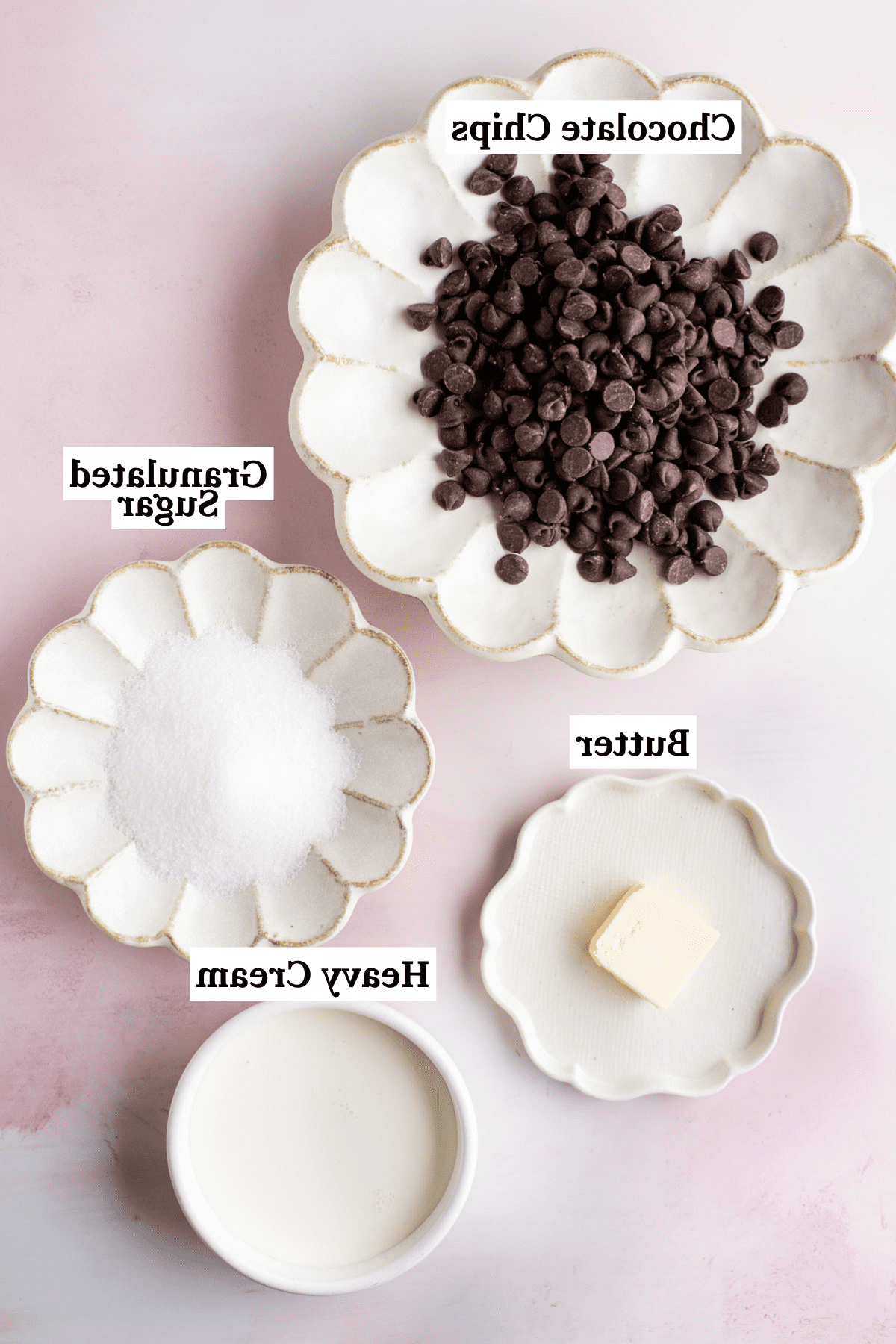 Gli ingredienti per la salsa hot fudge, inclusi panna fresca, zucchero semolato, gocce di cioccolato semi-dolce e burro