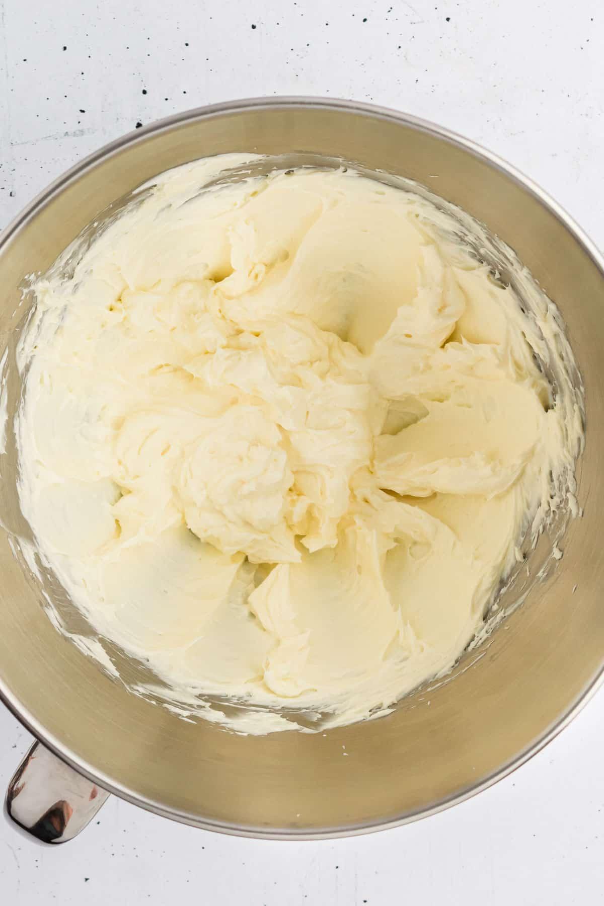 La base per la glassa di formaggio cremoso in una ciotola di miscelazione in metallo