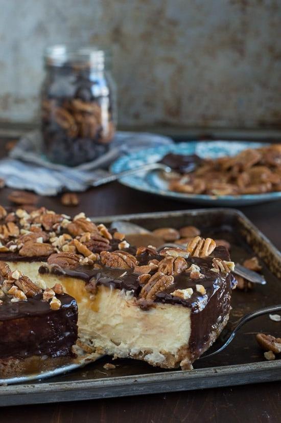 Questa è la migliore cheesecake tartaruga! È ricca e così cremosa. Guarnita con ganache al cioccolato, noci pecan e salsa al caramello.