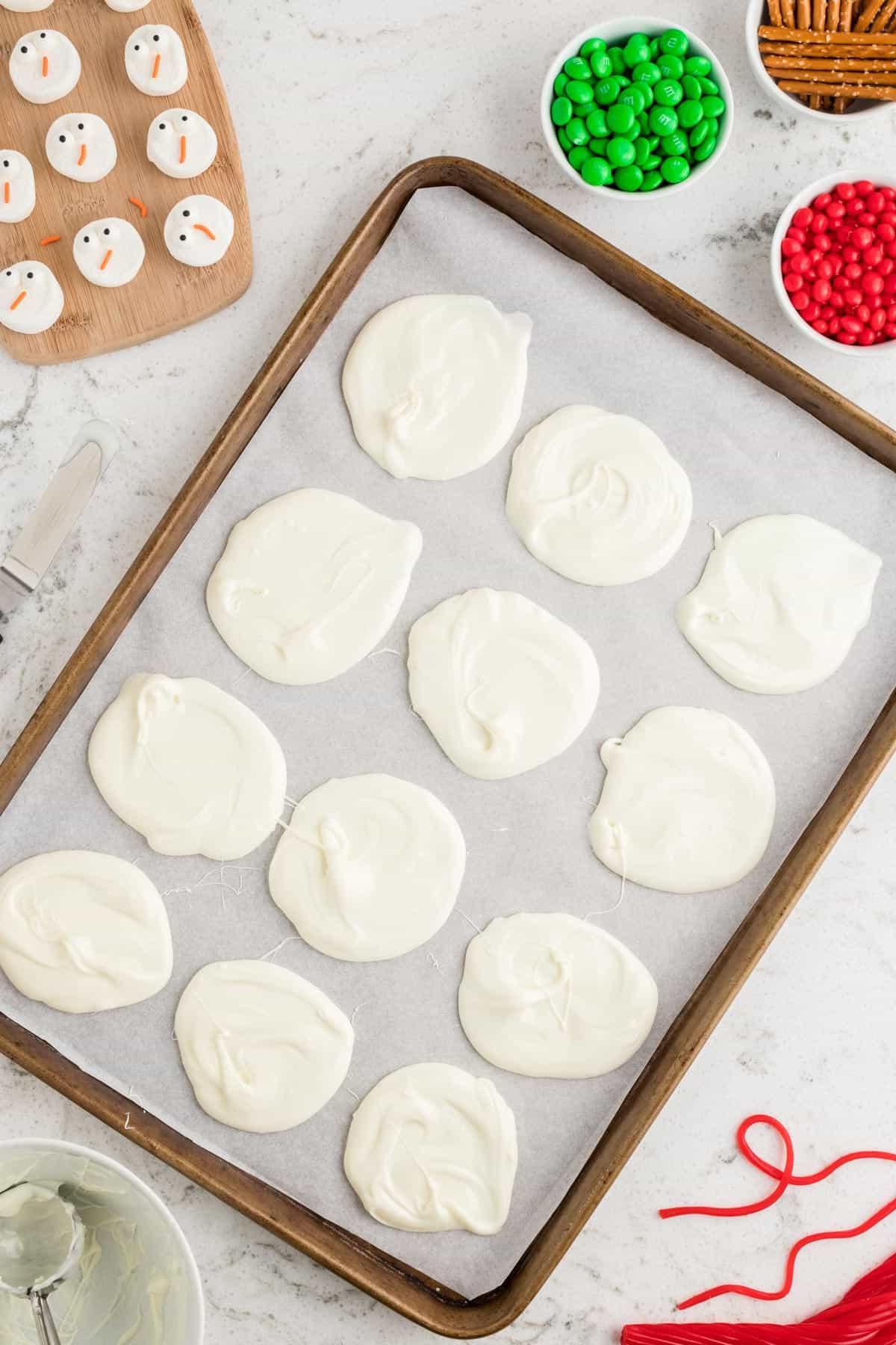 Corteccia del Pupazzo di Neve Sciolto 7 cioccolato bianco fuso steso in forma su carta forno