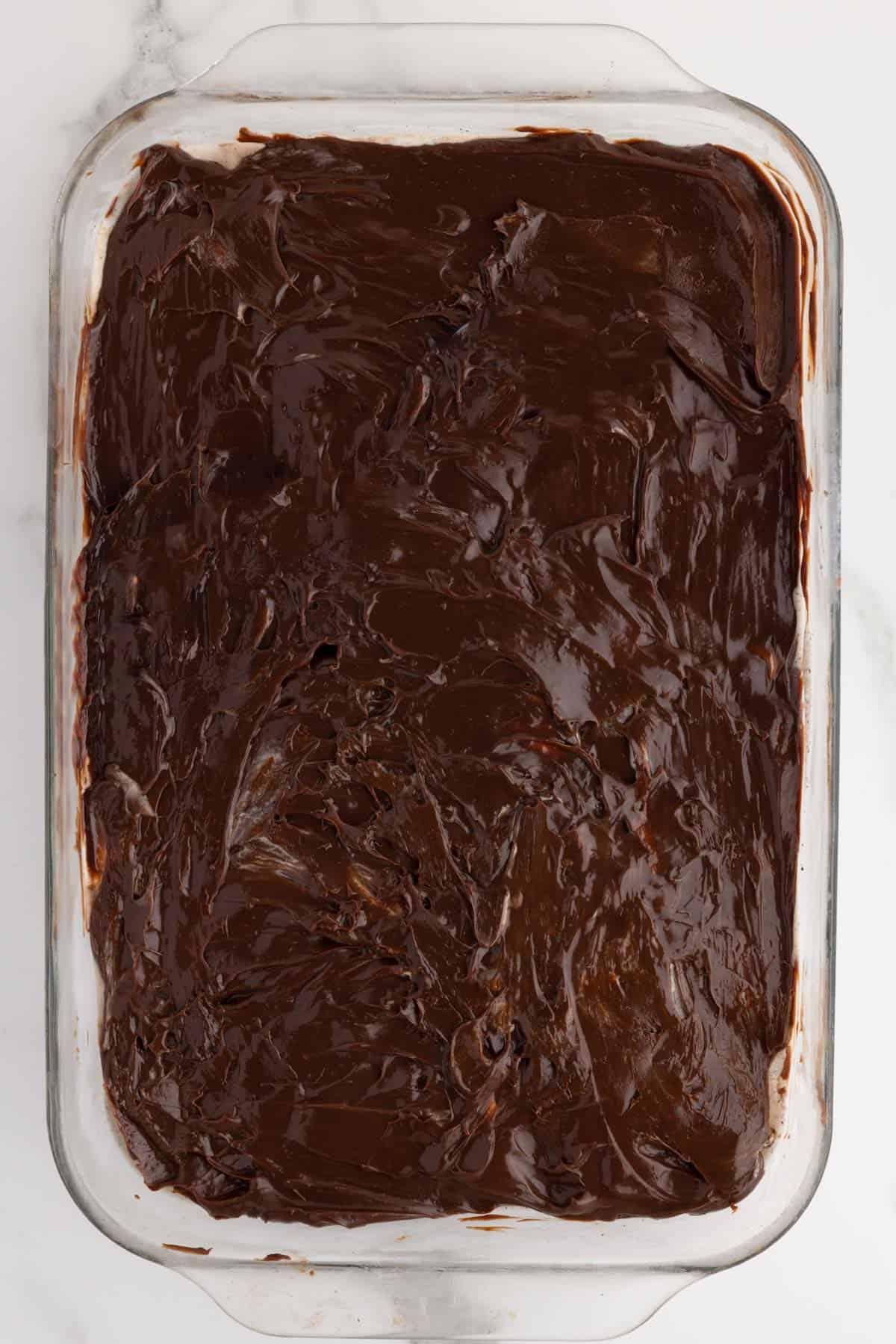 Ricetta Torta Gelato Oreo con 5 Ingredienti 7 Stati di torta gelato Oreo vengono aggiunti a una pirofila con lo strato di fudge caldo in evidenza sopra