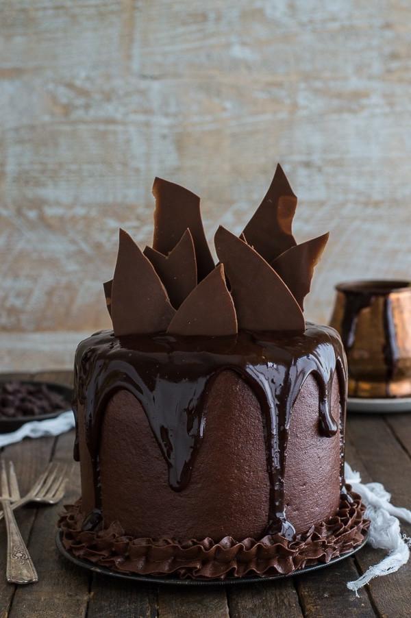 Torta al Cioccolato Cioccolato fatta in casa con frosting alla crema al burro al cioccolato su un piatto da portata.