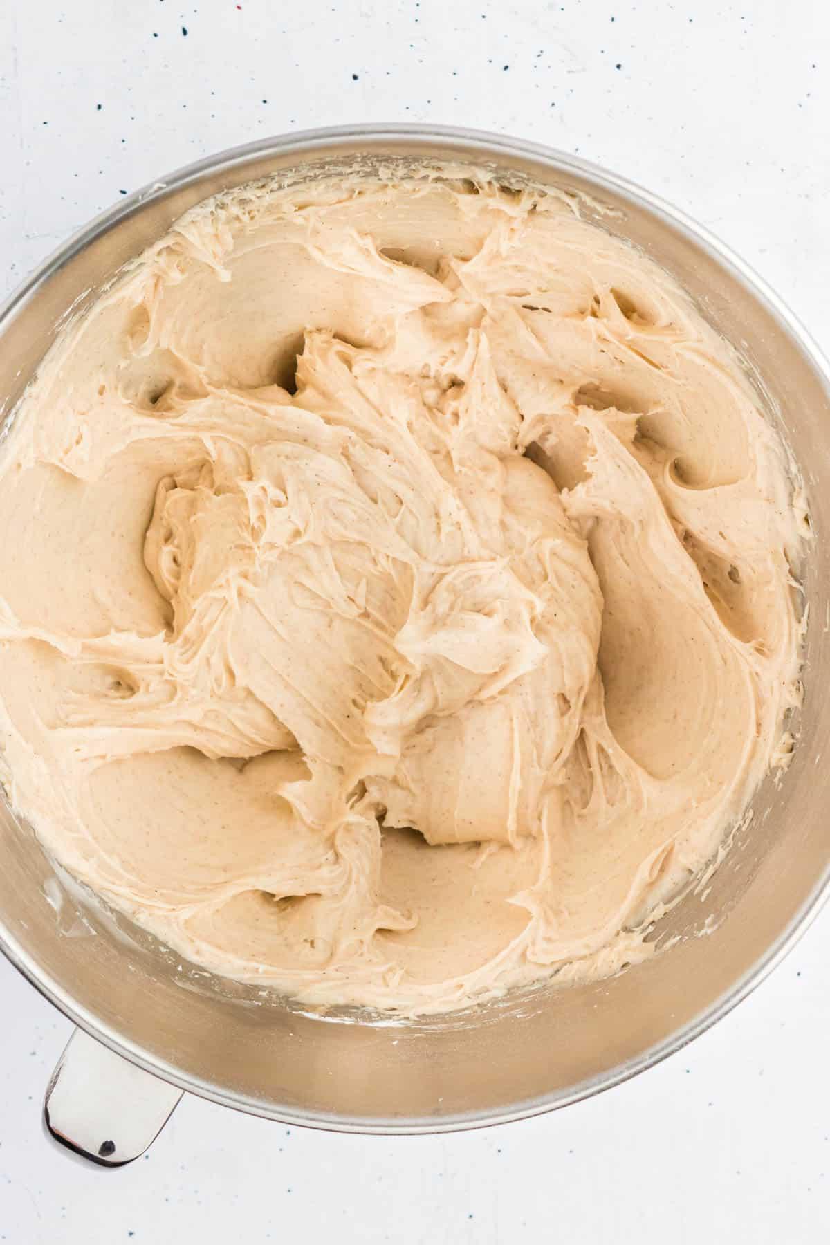 Glaseado de queso crema con canela en un tazón grande que acaba de ser combinado