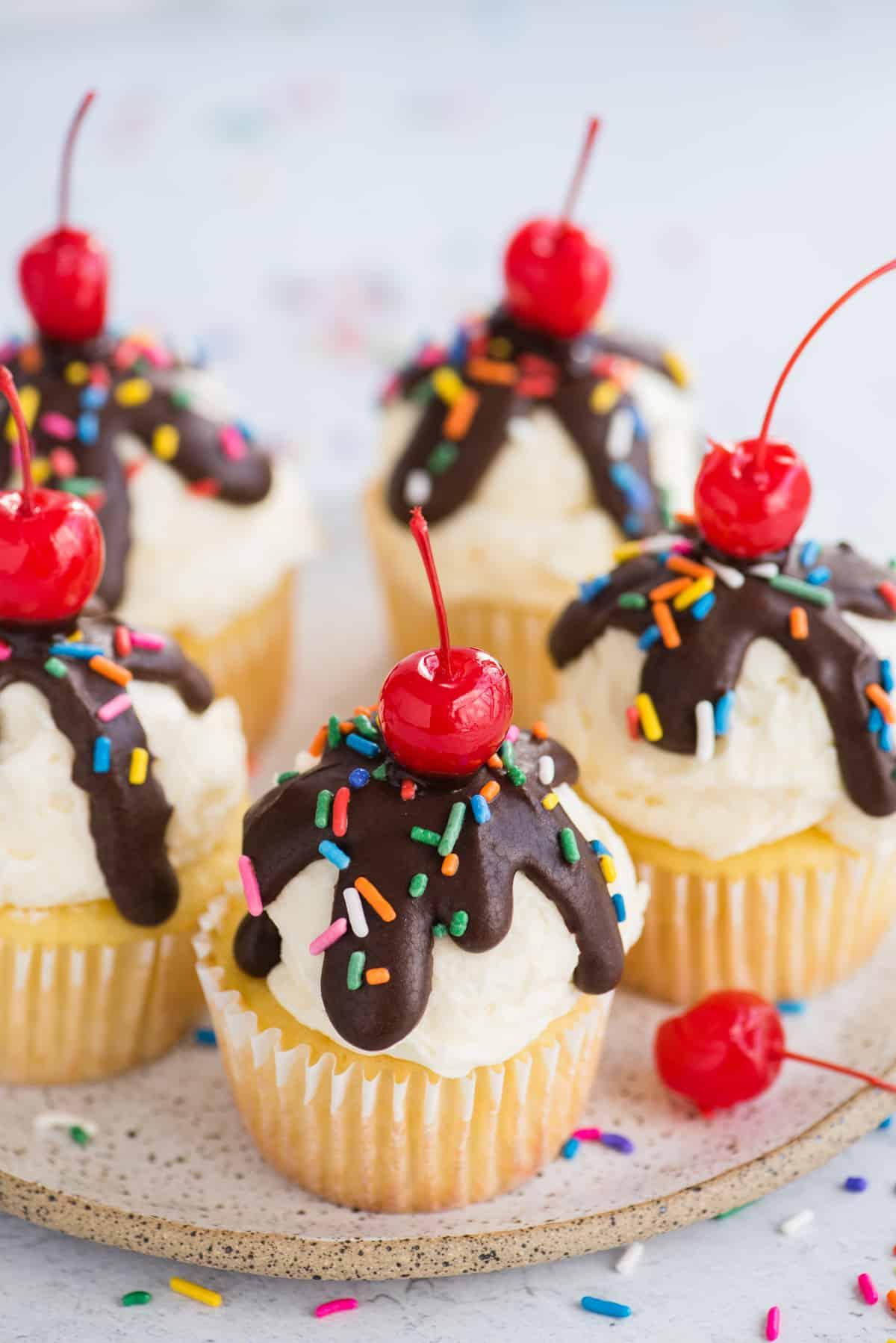 ice cream cupcakes displayed on white speckled plate on white background