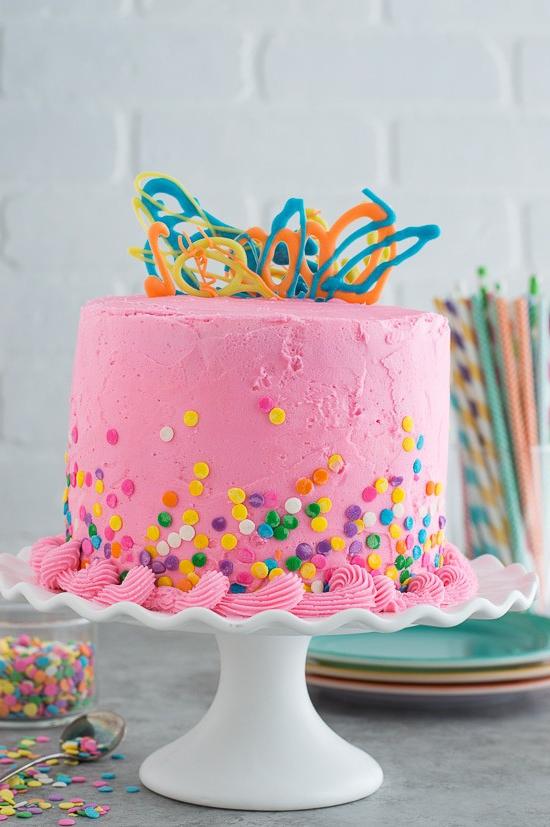 Questa torta rosa confetti con gocce di cioccolato è così divertente e colorata. Ci sono mini gocce di cioccolato all'interno della torta!