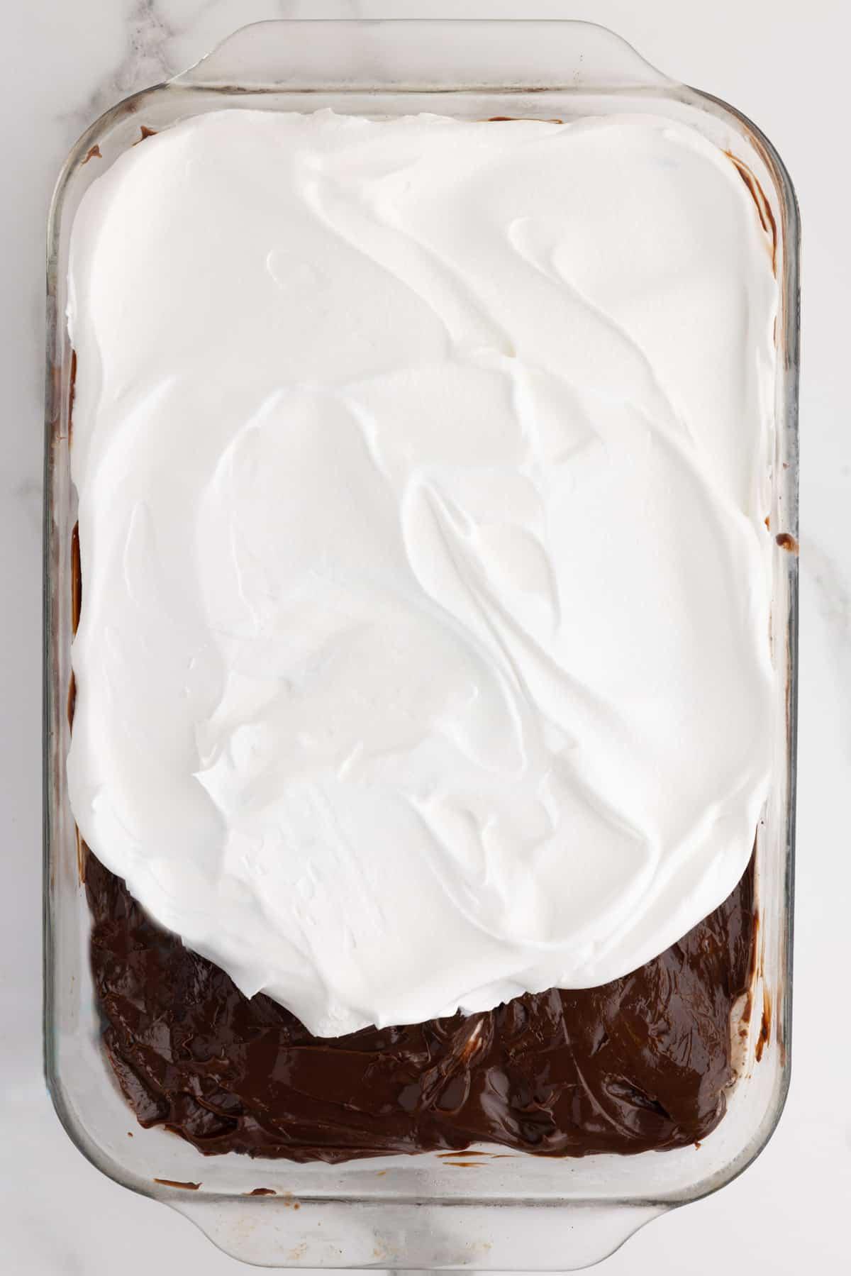 Ricetta Torta Gelato Oreo con 5 Ingredienti 8 Stati di torta gelato Oreo vengono aggiunti a una pirofila con lo strato di fudge caldo in evidenza e lo strato di Cool Whip semi-spalmato sopra