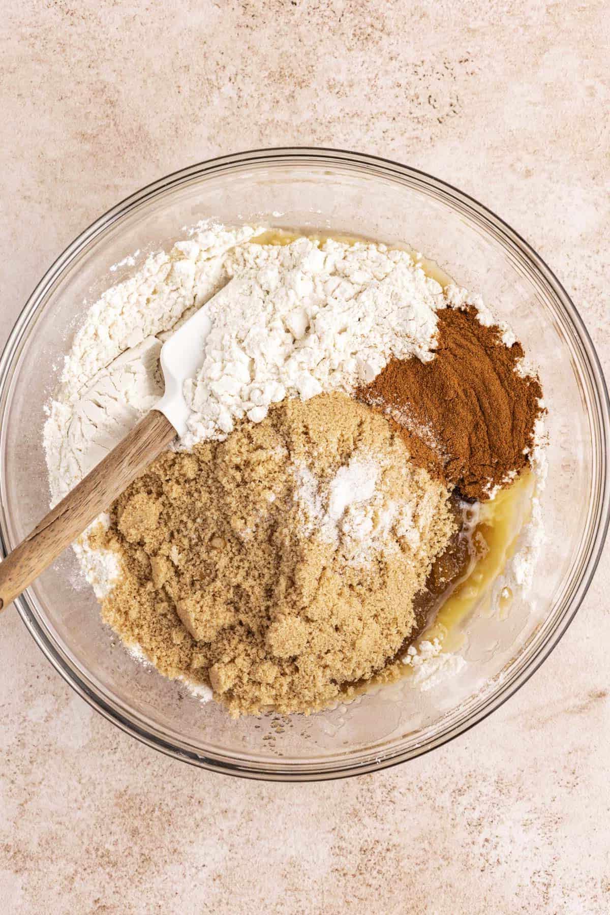 Ingredienti per la casseruola di French Toast in una ciotola di vetro trasparente con una miscela di farina, cannella e zucchero di canna sopra, non ancora mescolati.