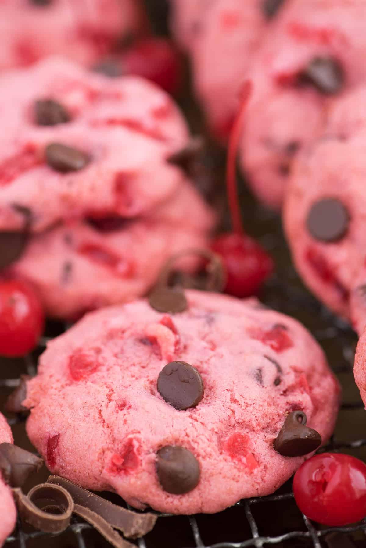 biscotti rosa alle ciliegie maraschino e gocce di cioccolato su teglia con ciliegie e gocce di cioccolato