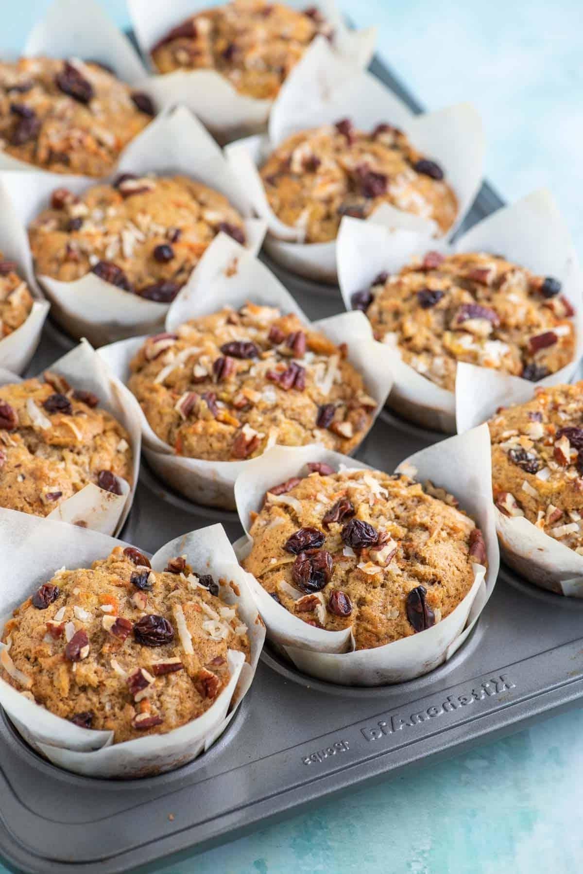 Muffin Morning Glory appena sfornati nei pirottini di carta all'interno di una teglia per muffin.
