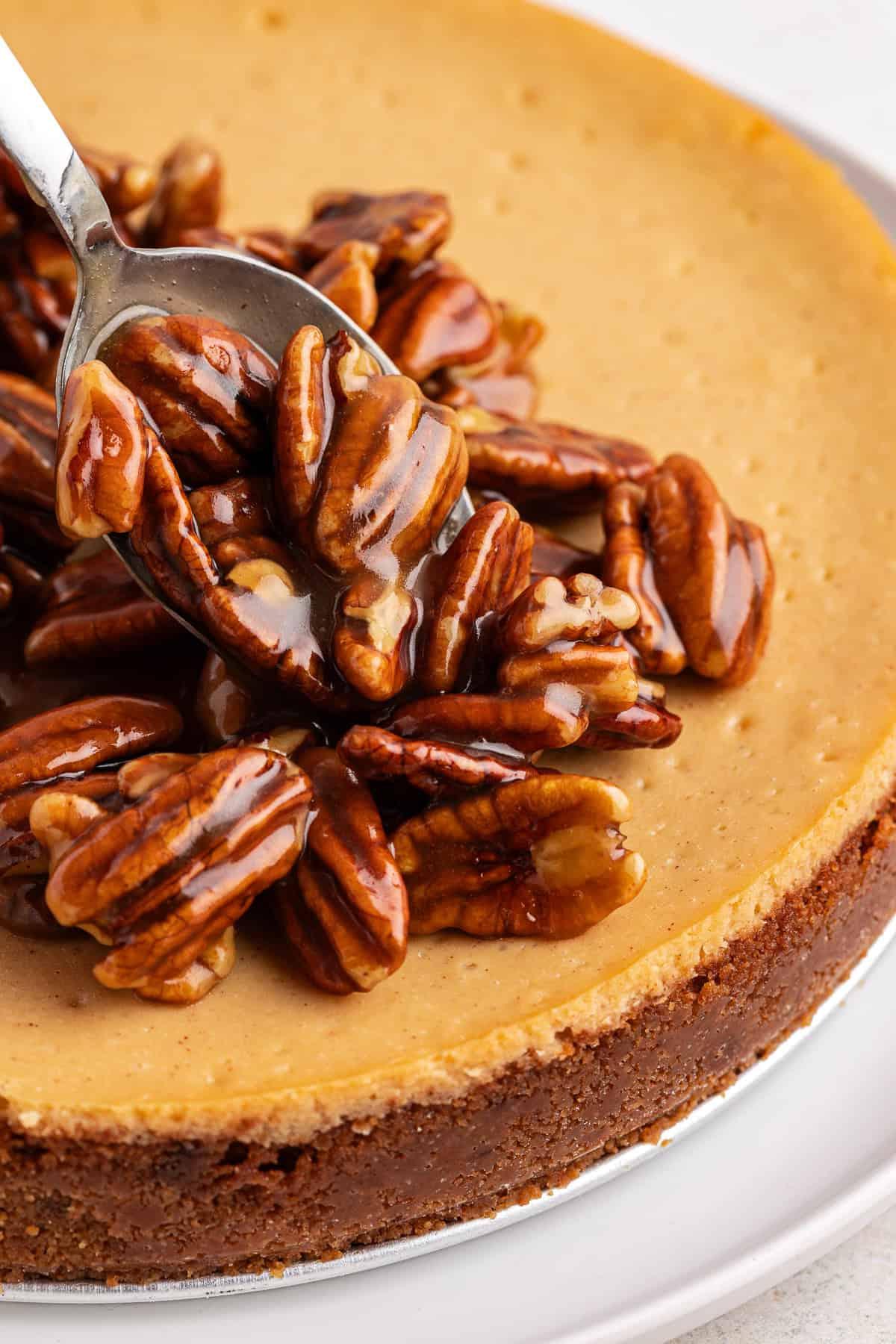 Ripieno di noci pecan versato a cucchiaiate sulla cheesecake